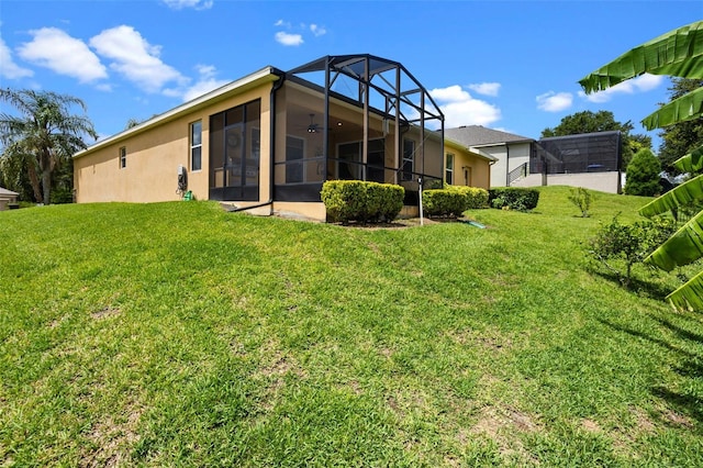 1892 Sanderling Dr, Clermont, FL 34711 - back of property featuring a yard, a ceiling fan, stucco siding, and a sunroom