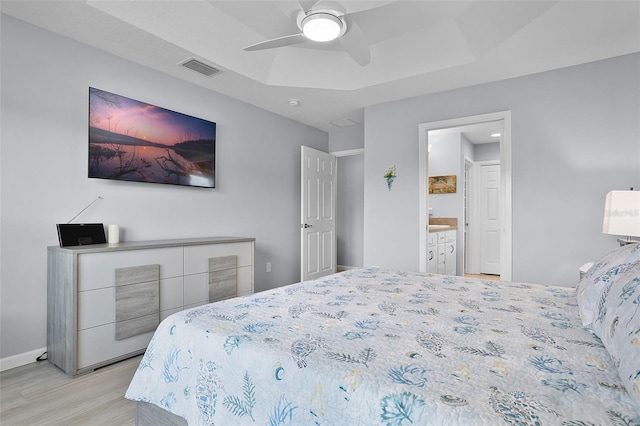 5778 Henry Loop, The Villages, FL 32163 - bedroom with light wood-type flooring, a raised ceiling, a ceiling fan, ensuite bath, and recessed lighting