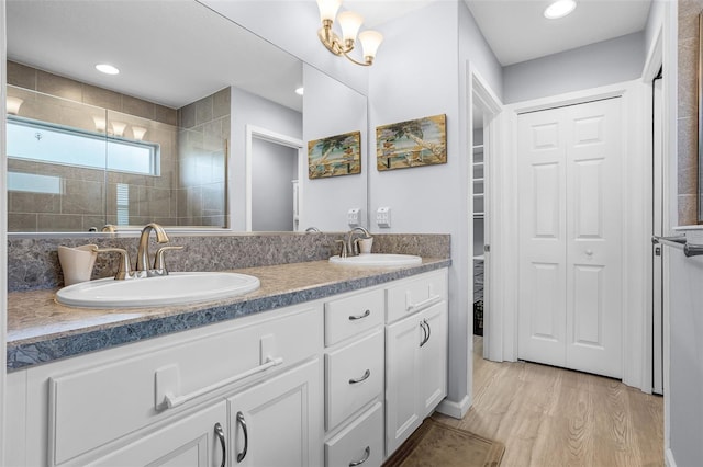 5778 Henry Loop, The Villages, FL 32163 - full bathroom featuring a closet, double vanity, wood finished floors, and tiled shower