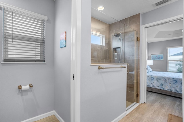 5778 Henry Loop, The Villages, FL 32163 - ensuite bathroom with a walk in shower, wood finished floors, and plenty of natural light