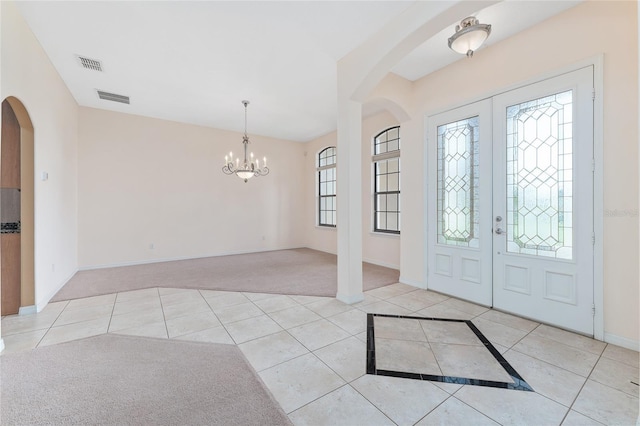 21312 Marsh View Ct, Clermont, FL 34715 - tiled foyer with arched walkways, a chandelier, and carpet floors