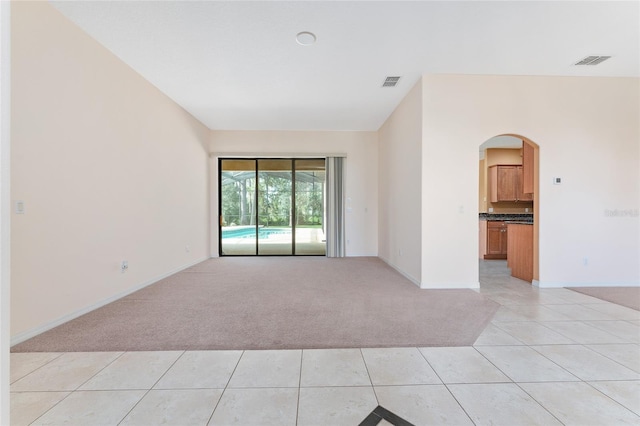 21312 Marsh View Ct, Clermont, FL 34715 - spare room featuring light colored carpet, light tile patterned floors, and arched walkways