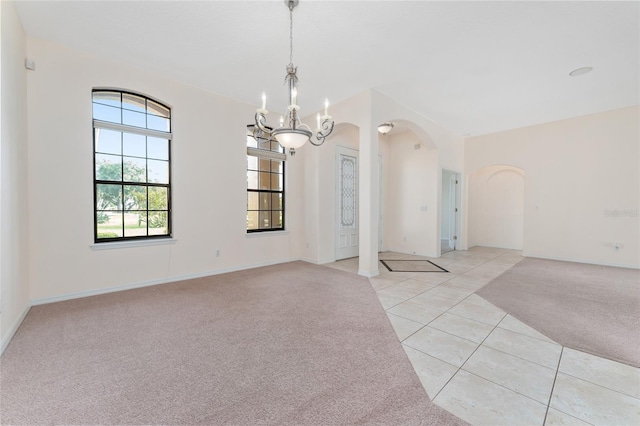 21312 Marsh View Ct, Clermont, FL 34715 - spare room with arched walkways, light carpet, a chandelier, and light tile patterned floors