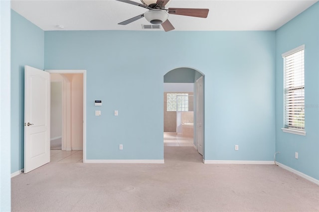21312 Marsh View Ct, Clermont, FL 34715 - unfurnished bedroom with arched walkways, carpet, ceiling fan, and ensuite bath