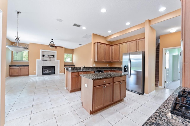 21312 Marsh View Ct, Clermont, FL 34715 - kitchen with stainless steel appliances, a ceiling fan, a kitchen island, a fireplace, and a peninsula