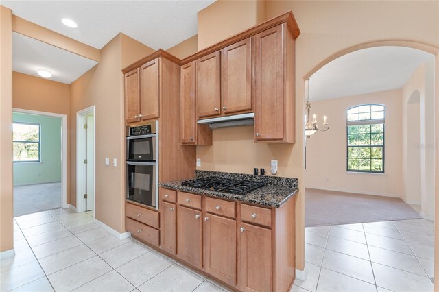 21312 Marsh View Ct, Clermont, FL 34715 - kitchen with light colored carpet, light tile patterned floors, stainless steel double oven, dark stone counters, and gas stovetop