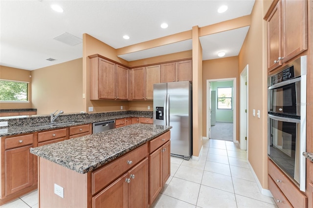 21312 Marsh View Ct, Clermont, FL 34715 - kitchen featuring stainless steel appliances, dark stone counters, a kitchen island, plenty of natural light, and recessed lighting
