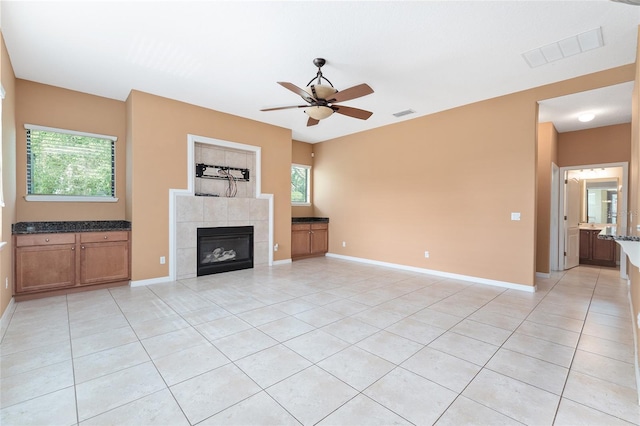 21312 Marsh View Ct, Clermont, FL 34715 - unfurnished living room featuring ceiling fan, light tile patterned flooring, and a fireplace