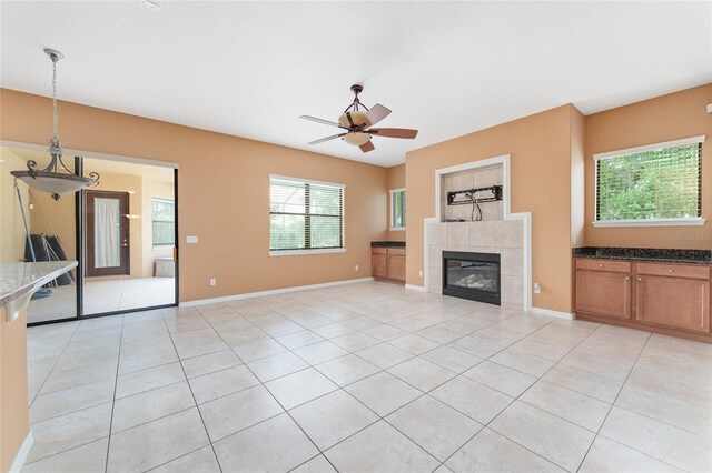 21312 Marsh View Ct, Clermont, FL 34715 - unfurnished living room with light tile patterned flooring, a ceiling fan, and a tile fireplace