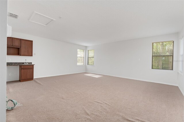 21312 Marsh View Ct, Clermont, FL 34715 - unfurnished living room featuring attic access and light colored carpet