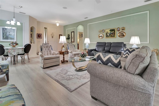3507 Arlington Ridge Blvd, Leesburg, FL 34748 - living room featuring arched walkways, light wood finished floors, a chandelier, and ceiling fan
