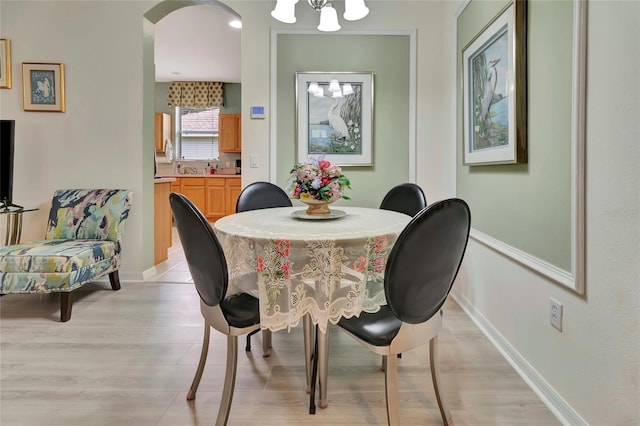 3507 Arlington Ridge Blvd, Leesburg, FL 34748 - dining area with light wood-style flooring, a chandelier, and arched walkways