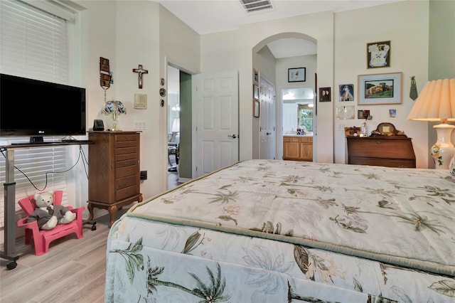 3507 Arlington Ridge Blvd, Leesburg, FL 34748 - bedroom featuring arched walkways, light wood finished floors, and ensuite bath