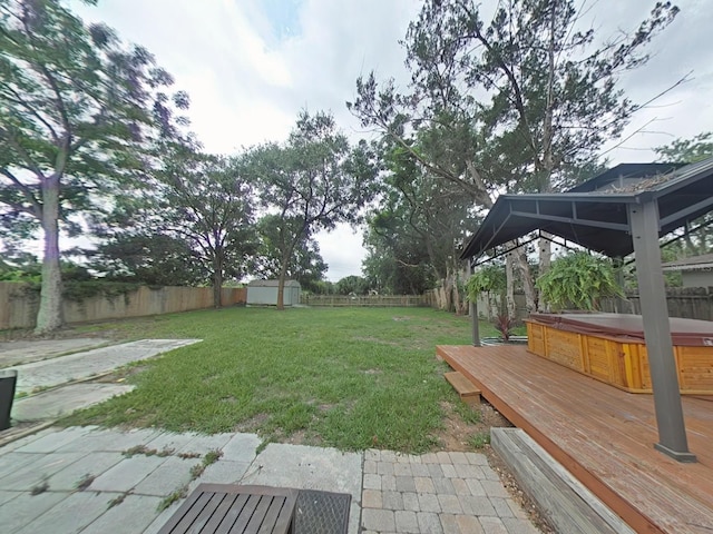 1610 Williams Ave, Eustis, FL 32726 - fenced backyard with a hot tub, a storage shed, a gazebo, a patio area, and a deck