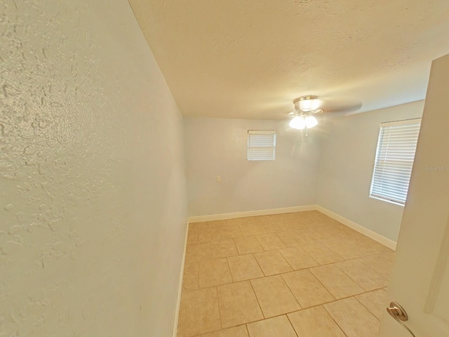 1610 Williams Ave, Eustis, FL 32726 - spare room with ceiling fan, a textured ceiling, light tile patterned flooring, and a textured wall