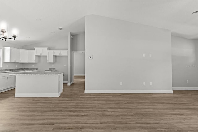 8641 N Stern Way, Citrus Springs, FL 34434 - kitchen with white cabinets, vaulted ceiling, wood finished floors, a kitchen island, and open floor plan
