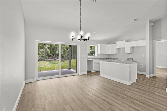 8641 N Stern Way, Citrus Springs, FL 34434 - kitchen with a chandelier, light wood-type flooring, a kitchen island, white cabinetry, and hanging light fixtures