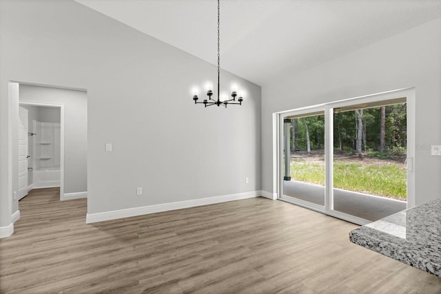 8641 N Stern Way, Citrus Springs, FL 34434 - unfurnished dining area featuring a chandelier, high vaulted ceiling, and wood finished floors