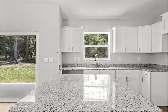 8641 N Stern Way, Citrus Springs, FL 34434 - kitchen featuring light stone countertops, white cabinets, and wood finished floors