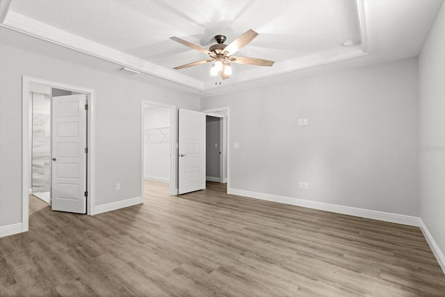 8641 N Stern Way, Citrus Springs, FL 34434 - unfurnished bedroom with wood finished floors, a walk in closet, a closet, and a ceiling fan