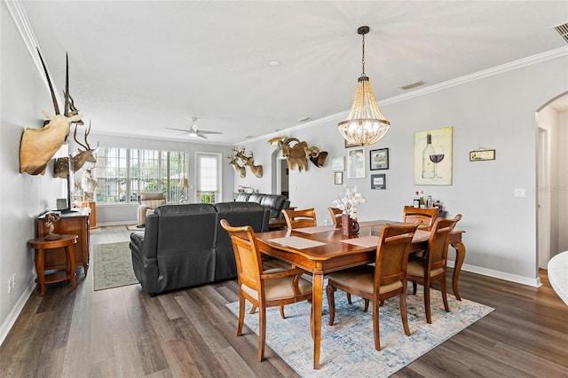 5971 Brittania Blvd, Tavares, FL 32778 - dining area with arched walkways, dark wood-type flooring, ornamental molding, a ceiling fan, and a chandelier