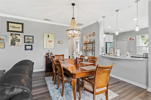 5971 Brittania Blvd, Tavares, FL 32778 - dining area with dark wood finished floors, a chandelier, crown molding, and recessed lighting