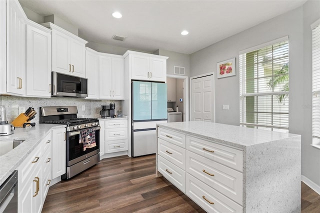 5971 Brittania Blvd, Tavares, FL 32778 - kitchen with appliances with stainless steel finishes, washer / dryer, backsplash, recessed lighting, and dark wood-type flooring