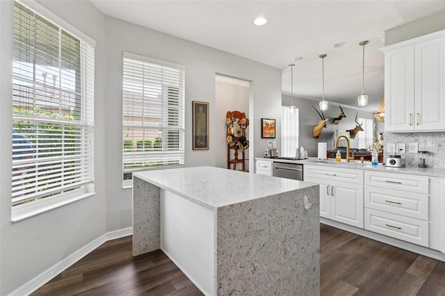 5971 Brittania Blvd, Tavares, FL 32778 - kitchen with stainless steel dishwasher, dark wood finished floors, light stone countertops, decorative backsplash, and decorative light fixtures