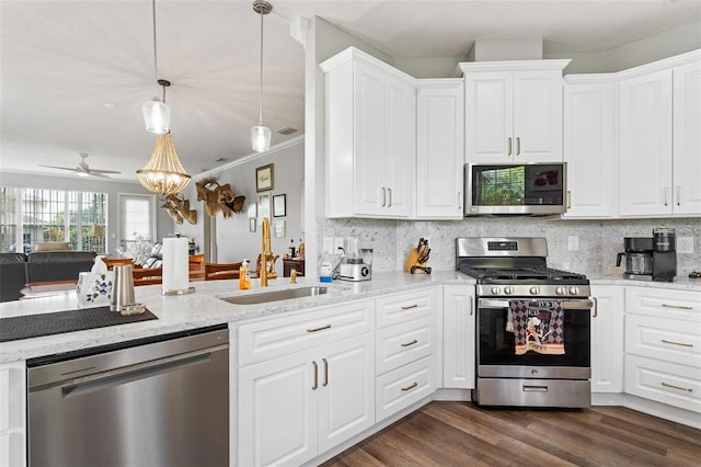 5971 Brittania Blvd, Tavares, FL 32778 - kitchen featuring stainless steel appliances, backsplash, white cabinetry, a ceiling fan, and light stone counters