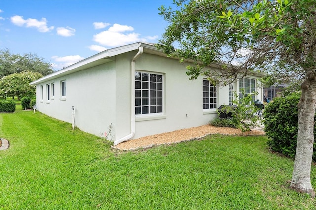 5971 Brittania Blvd, Tavares, FL 32778 - view of side of property with stucco siding and a lawn