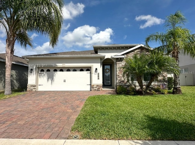 384 Summer Squall Rd, Davenport, FL 33837 - view of front of house with stone siding, a garage, decorative driveway, stucco siding, and a front lawn
