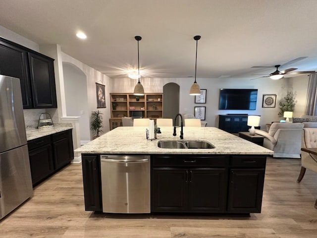 384 Summer Squall Rd, Davenport, FL 33837 - kitchen featuring stainless steel appliances, dark cabinets, open floor plan, an island with sink, and recessed lighting