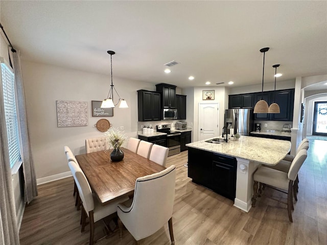 384 Summer Squall Rd, Davenport, FL 33837 - dining space featuring light wood-style flooring, recessed lighting, and arched walkways