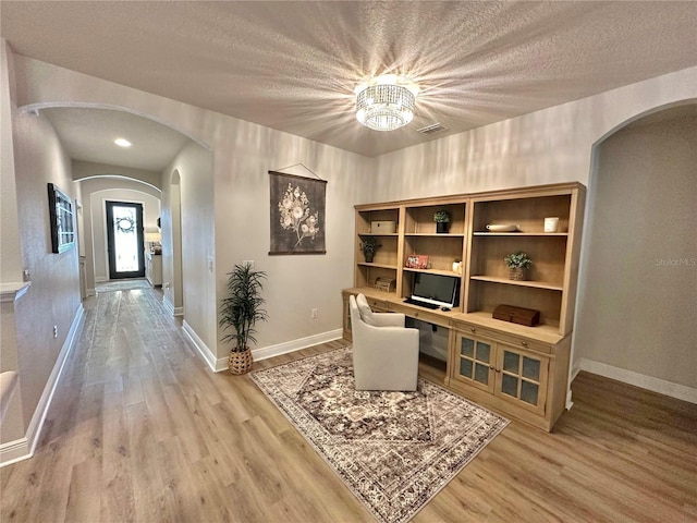 384 Summer Squall Rd, Davenport, FL 33837 - office area with arched walkways, light wood-style flooring, and a textured ceiling
