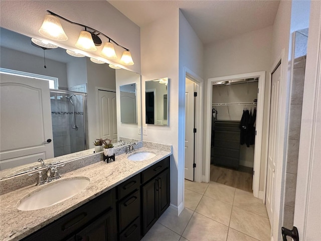 384 Summer Squall Rd, Davenport, FL 33837 - bathroom with a shower stall, double vanity, a walk in closet, and tile patterned flooring
