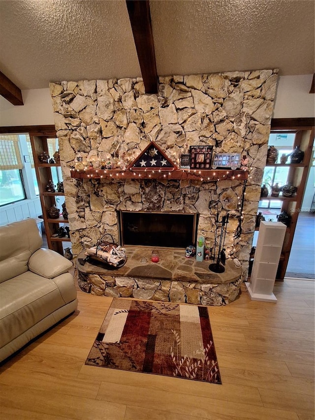 29205 Old Ml E, Tavares, FL 32778 - living area with wood finished floors, beam ceiling, a textured ceiling, and a stone fireplace