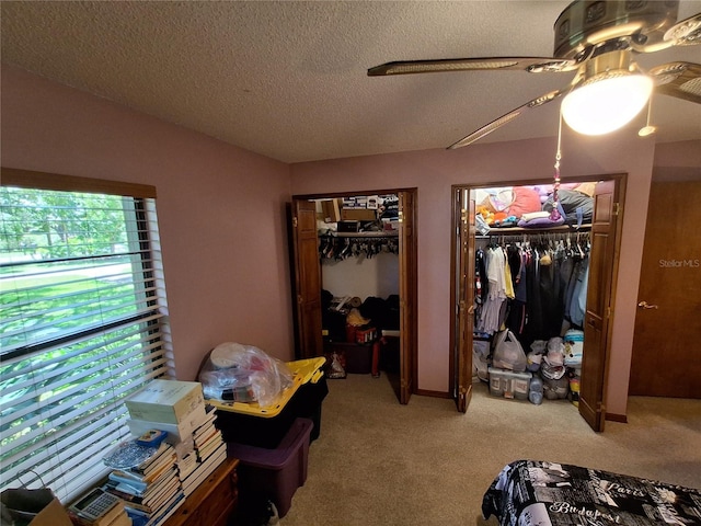 29205 Old Ml E, Tavares, FL 32778 - bedroom with multiple closets, light carpet, a textured ceiling, and a ceiling fan