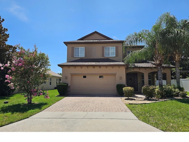 15604 Starlite St, Clermont, FL 34714 - traditional home featuring stucco siding, an attached garage, decorative driveway, and a front lawn