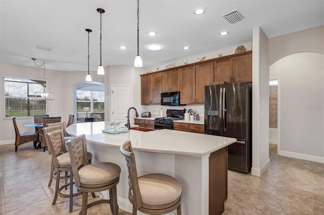 3681 Arlington Ridge Blvd, Leesburg, FL 34748 - kitchen featuring arched walkways, black appliances, a kitchen island with sink, light countertops, and recessed lighting