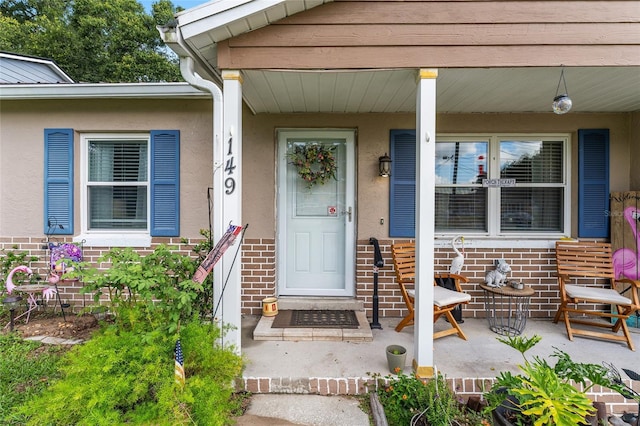 149 Shiloh Ave, Lady Lake, FL 32159 - property entrance with brick siding, covered porch, and stucco siding