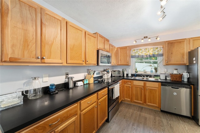 149 Shiloh Ave, Lady Lake, FL 32159 - kitchen with stainless steel appliances, wood finished floors, dark countertops, and rail lighting
