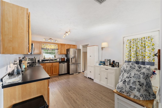 149 Shiloh Ave, Lady Lake, FL 32159 - kitchen featuring appliances with stainless steel finishes, dark countertops, a textured ceiling, and light wood-style floors