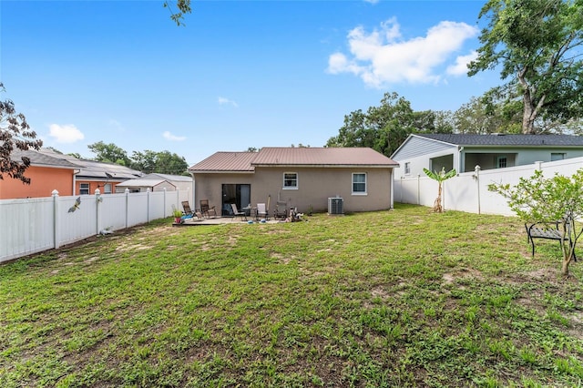 149 Shiloh Ave, Lady Lake, FL 32159 - back of property with a fenced backyard, stucco siding, a metal roof, and a patio area