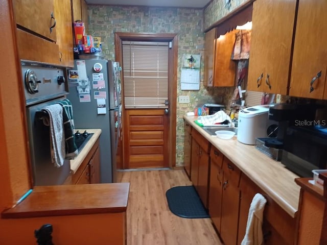 505 Richard St, Leesburg, FL 34748 - kitchen featuring oven, brown cabinetry, light wood finished floors, and freestanding refrigerator