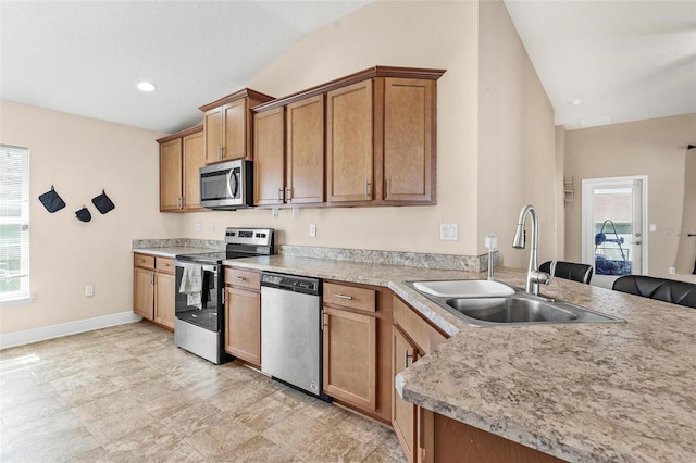7732 Sloewood Dr, Leesburg, FL 34748 - kitchen featuring appliances with stainless steel finishes, vaulted ceiling, a peninsula, light countertops, and brown cabinets