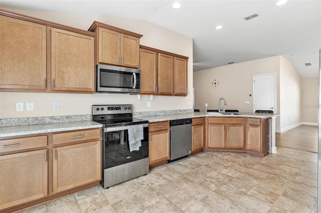 7732 Sloewood Dr, Leesburg, FL 34748 - kitchen with appliances with stainless steel finishes, a peninsula, light countertops, recessed lighting, and lofted ceiling