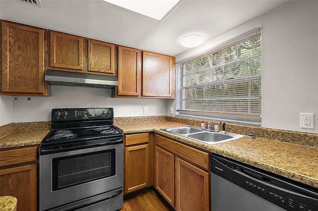 600 W Oak Terrace Dr, Leesburg, FL 34748 - kitchen with appliances with stainless steel finishes, under cabinet range hood, plenty of natural light, and brown cabinetry
