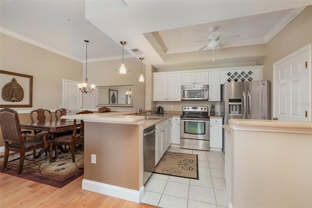 9025 Colby Dr Unit 2121, Fort Myers, FL 33919 - kitchen with stainless steel appliances, a peninsula, white cabinetry, ornamental molding, and ceiling fan