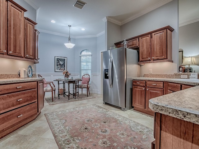 1982 Eldridge Loop, The Villages, FL 32162 - kitchen featuring stainless steel fridge, light countertops, crown molding, brown cabinets, and a decorative wall