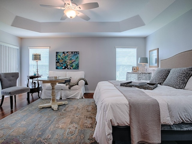 1982 Eldridge Loop, The Villages, FL 32162 - bedroom with a raised ceiling, wood finished floors, and a ceiling fan